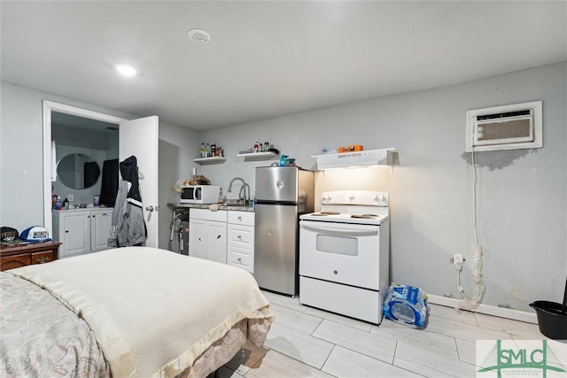 bedroom featuring a wall mounted AC, stainless steel fridge, and sink