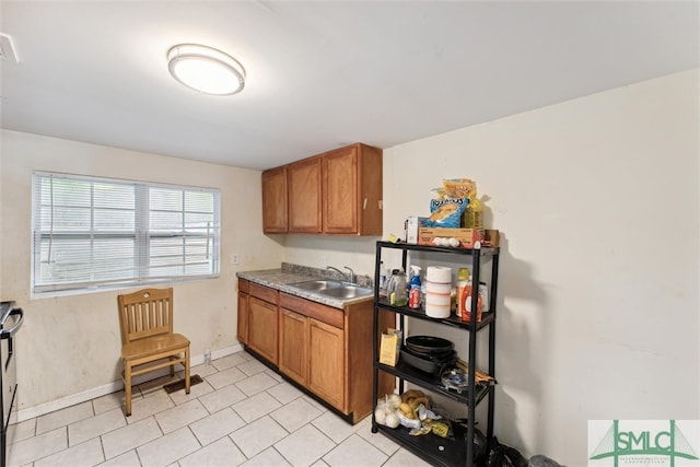 kitchen featuring light tile patterned floors and sink