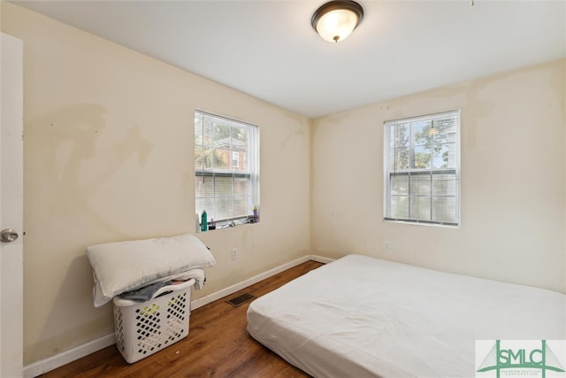 bedroom with hardwood / wood-style flooring and multiple windows