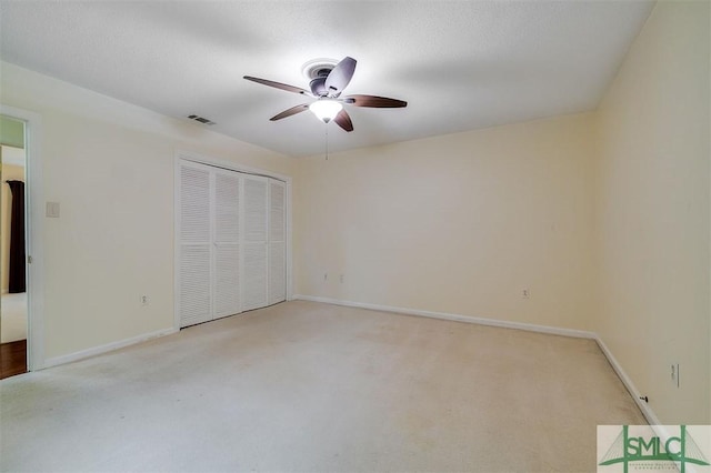 unfurnished bedroom with light colored carpet, a textured ceiling, and a closet