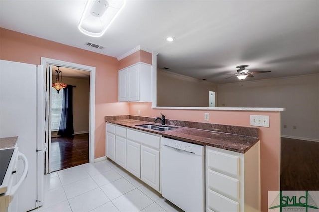 kitchen featuring sink, white appliances, white cabinets, light tile patterned flooring, and kitchen peninsula