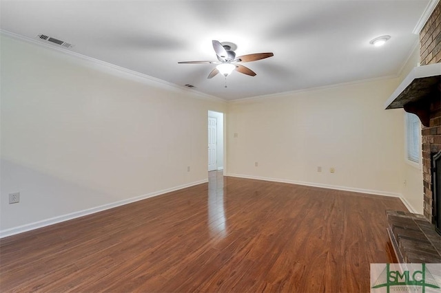 unfurnished living room featuring dark hardwood / wood-style flooring, a brick fireplace, crown molding, and ceiling fan