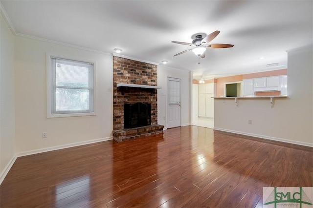 unfurnished living room featuring crown molding, a fireplace, dark hardwood / wood-style floors, and ceiling fan