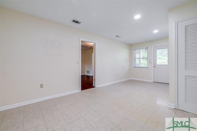 unfurnished room with a textured ceiling