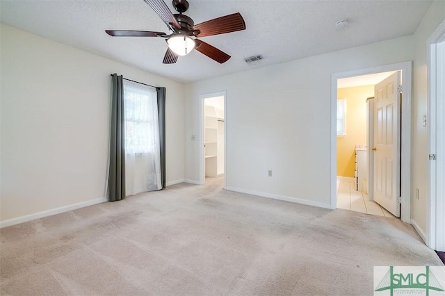 carpeted empty room featuring ceiling fan and a textured ceiling