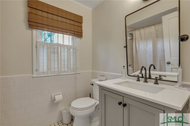 bathroom with tile walls, toilet, vanity, and ornamental molding