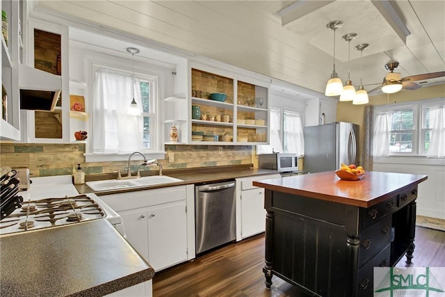 kitchen featuring appliances with stainless steel finishes, pendant lighting, a center island, and sink