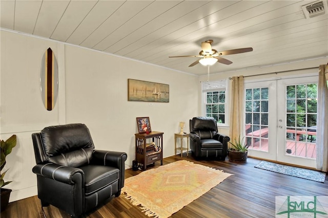 sitting room with dark wood-type flooring, ceiling fan, french doors, and crown molding