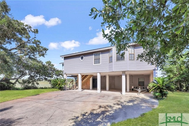 rear view of property with a carport and a yard