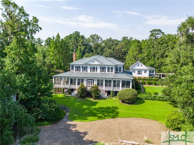 back of house featuring a sunroom, a lawn, and a porch