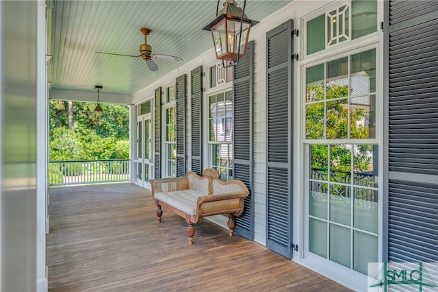 wooden deck featuring covered porch and ceiling fan