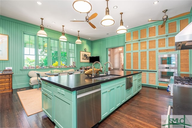 kitchen with a kitchen island with sink, decorative light fixtures, sink, ceiling fan, and appliances with stainless steel finishes