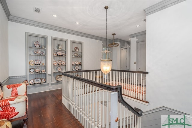 hall with built in features, ornamental molding, and dark hardwood / wood-style floors