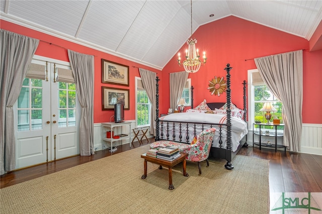 bedroom featuring an inviting chandelier, multiple windows, lofted ceiling, and hardwood / wood-style flooring