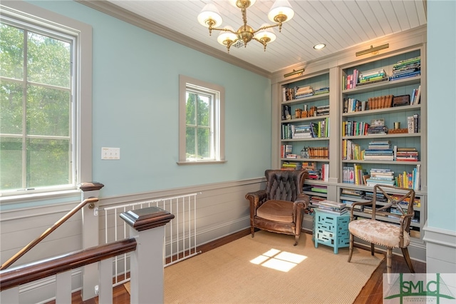 sitting room featuring a notable chandelier, ornamental molding, and a wealth of natural light