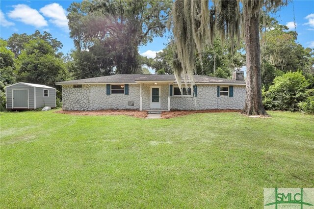 single story home featuring a shed and a front lawn