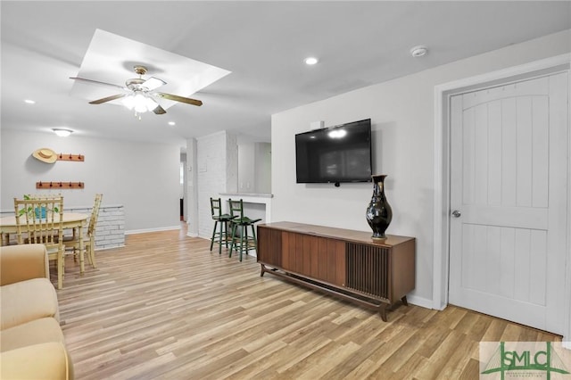 living room with light hardwood / wood-style flooring and ceiling fan