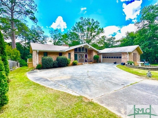 ranch-style house featuring a garage and a front yard