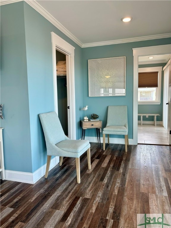 sitting room featuring dark wood-style floors, baseboards, and crown molding