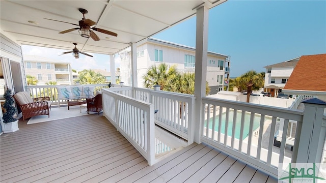 deck with a residential view, outdoor lounge area, ceiling fan, and fence