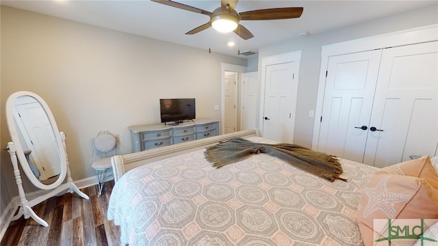 bedroom with dark wood-style flooring, a closet, a ceiling fan, visible vents, and baseboards
