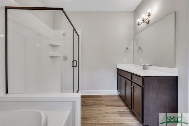 bathroom featuring hardwood / wood-style floors, vanity, and independent shower and bath