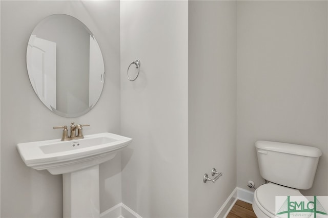 bathroom featuring hardwood / wood-style floors, toilet, and sink