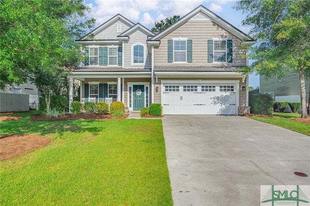 view of front of home with a garage, a front lawn, and covered porch