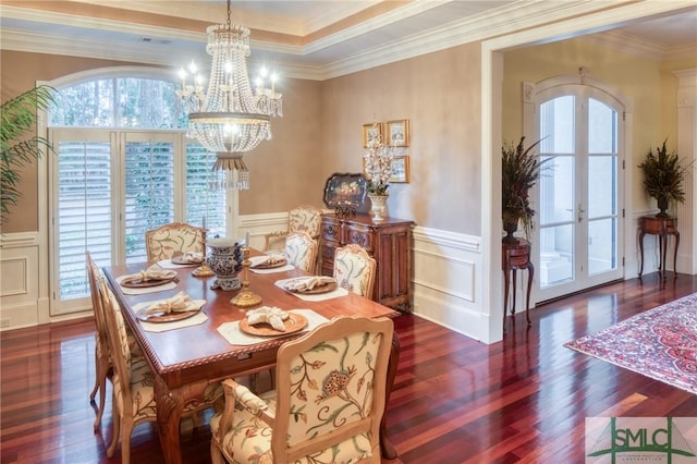 dining area featuring a wainscoted wall, a notable chandelier, a wealth of natural light, and french doors