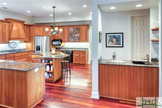 kitchen featuring brown cabinetry, dark wood-style floors, appliances with stainless steel finishes, open shelves, and a sink