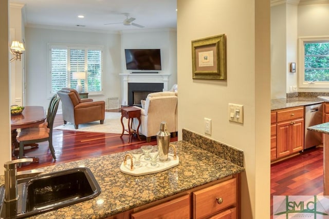 kitchen featuring a sink, crown molding, brown cabinetry, and stainless steel dishwasher