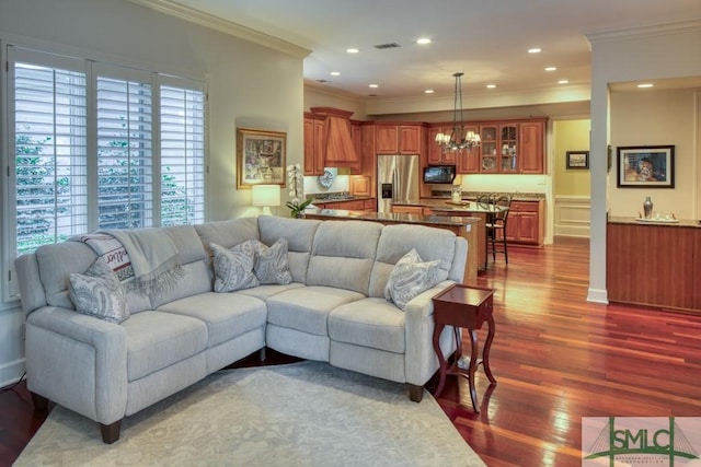 living area featuring visible vents, dark wood-style floors, ornamental molding, a notable chandelier, and recessed lighting