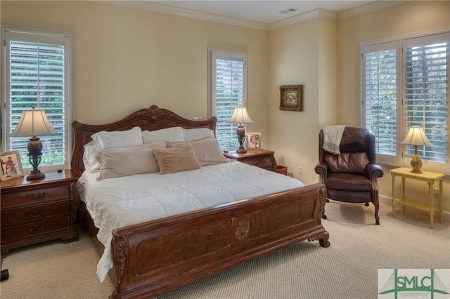 bedroom with carpet floors, ornamental molding, visible vents, and baseboards