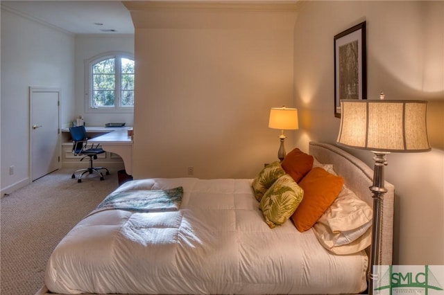 bedroom with ornamental molding and carpet