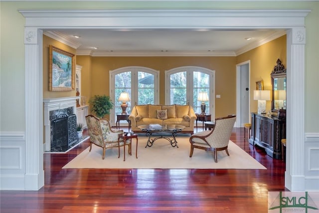 living area featuring ornamental molding, a fireplace, and wood finished floors