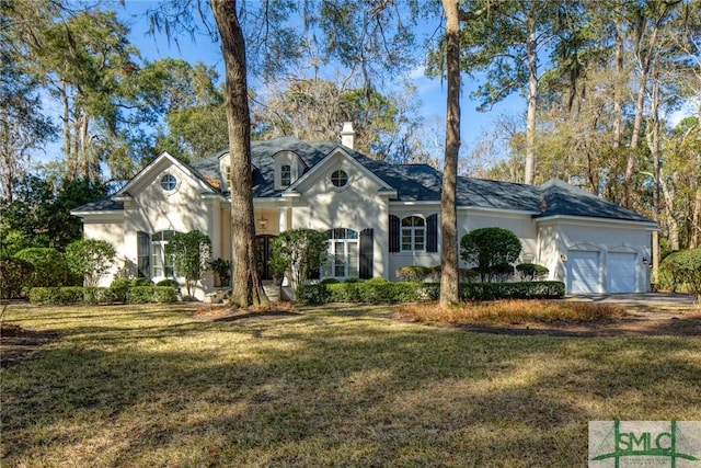 view of front of property with a garage, a front yard, and stucco siding