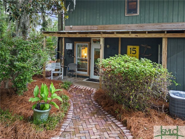 view of exterior entry featuring central air condition unit