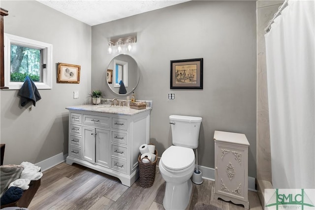 bathroom with hardwood / wood-style flooring, vanity, a textured ceiling, and toilet