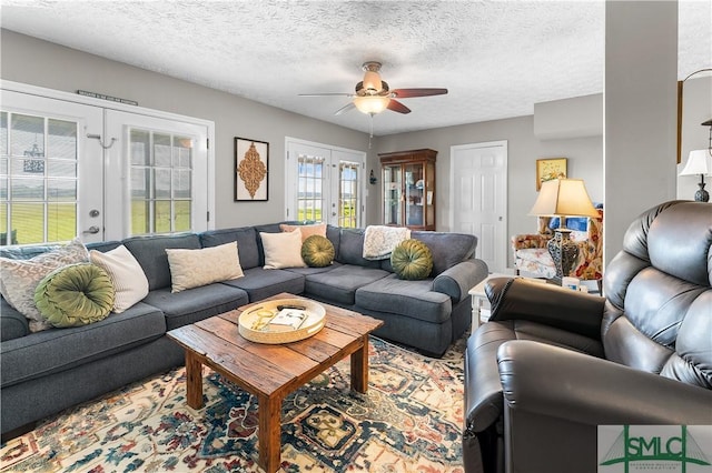 living room with a textured ceiling, ceiling fan, and french doors