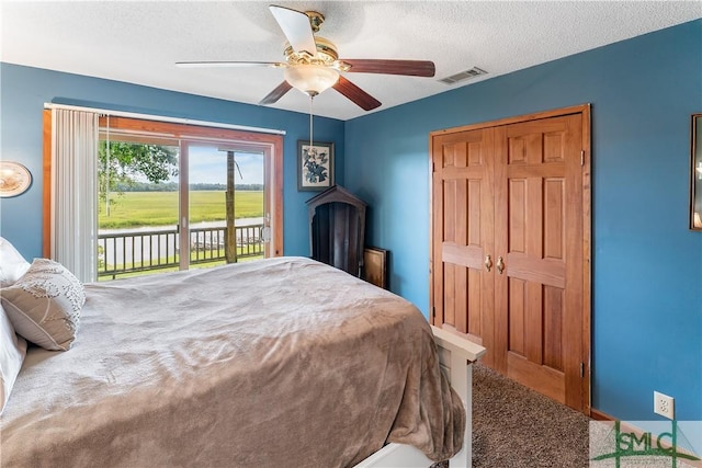 bedroom featuring access to exterior, a textured ceiling, and ceiling fan