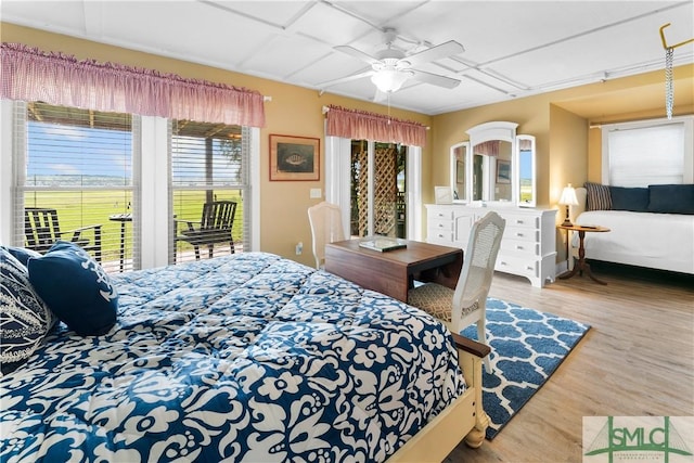 bedroom with ceiling fan, wood-type flooring, and access to outside