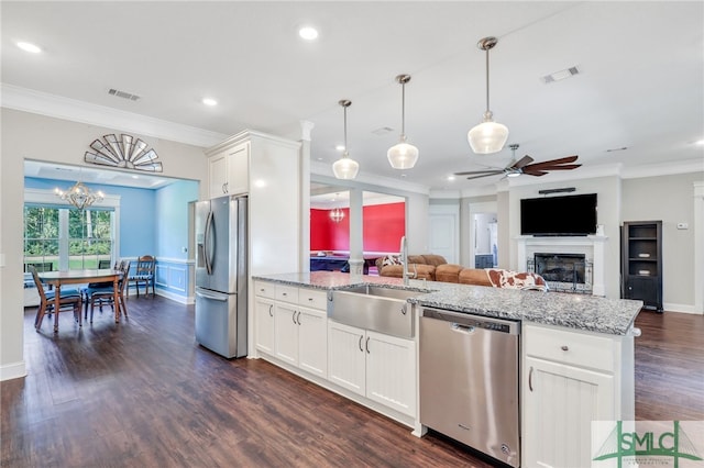 kitchen featuring stainless steel appliances, white cabinets, sink, light stone countertops, and dark wood-type flooring