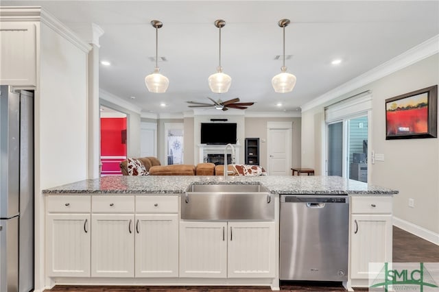 kitchen with stainless steel appliances, sink, ceiling fan, wood-type flooring, and ornamental molding