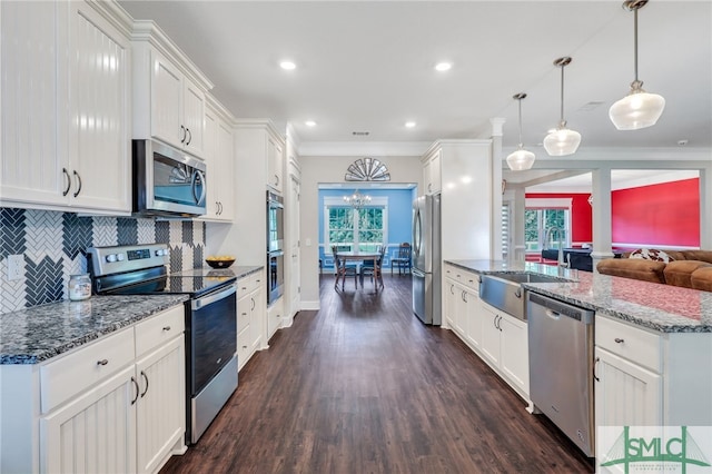 kitchen featuring dark hardwood / wood-style floors, crown molding, backsplash, and stainless steel appliances