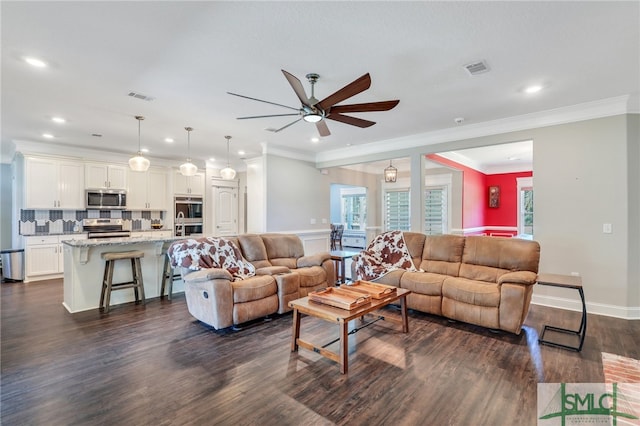 living room featuring dark hardwood / wood-style floors, crown molding, and ceiling fan