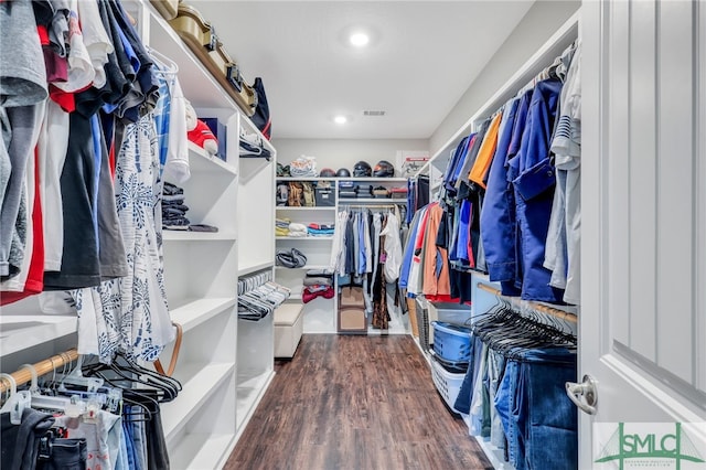 walk in closet with dark hardwood / wood-style flooring