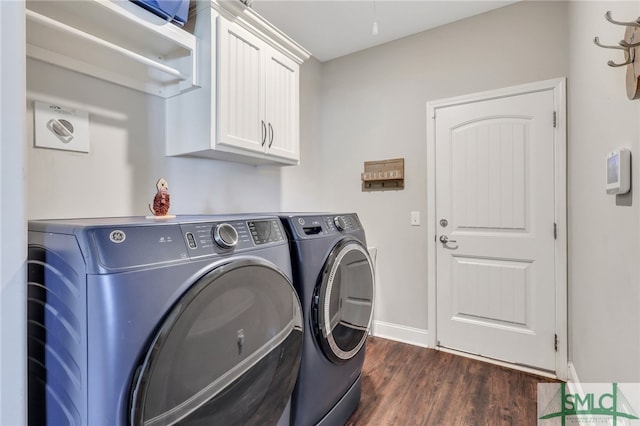 laundry room featuring dark hardwood / wood-style floors, washer and clothes dryer, and cabinets