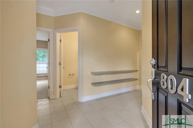 foyer featuring light tile patterned floors and ornamental molding