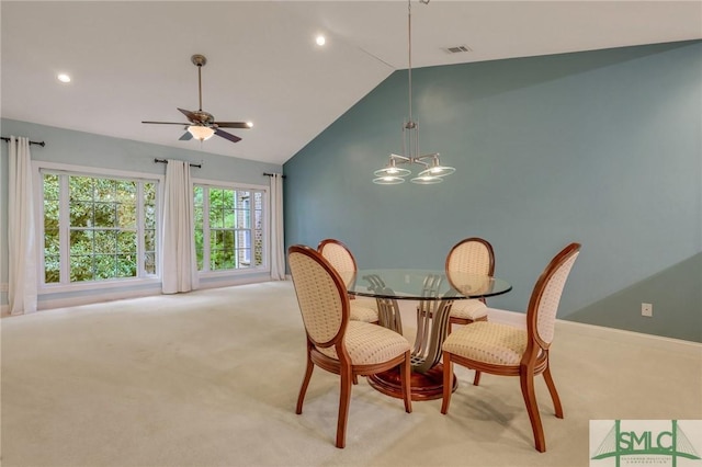 carpeted dining room featuring ceiling fan with notable chandelier and lofted ceiling