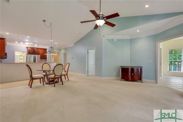 dining space with ceiling fan, light carpet, and lofted ceiling